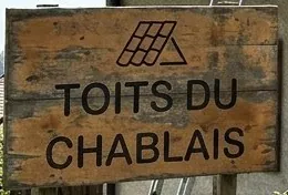 Panneau en bois des Toits du Chablais devant un chantier de toiture à Draillant
